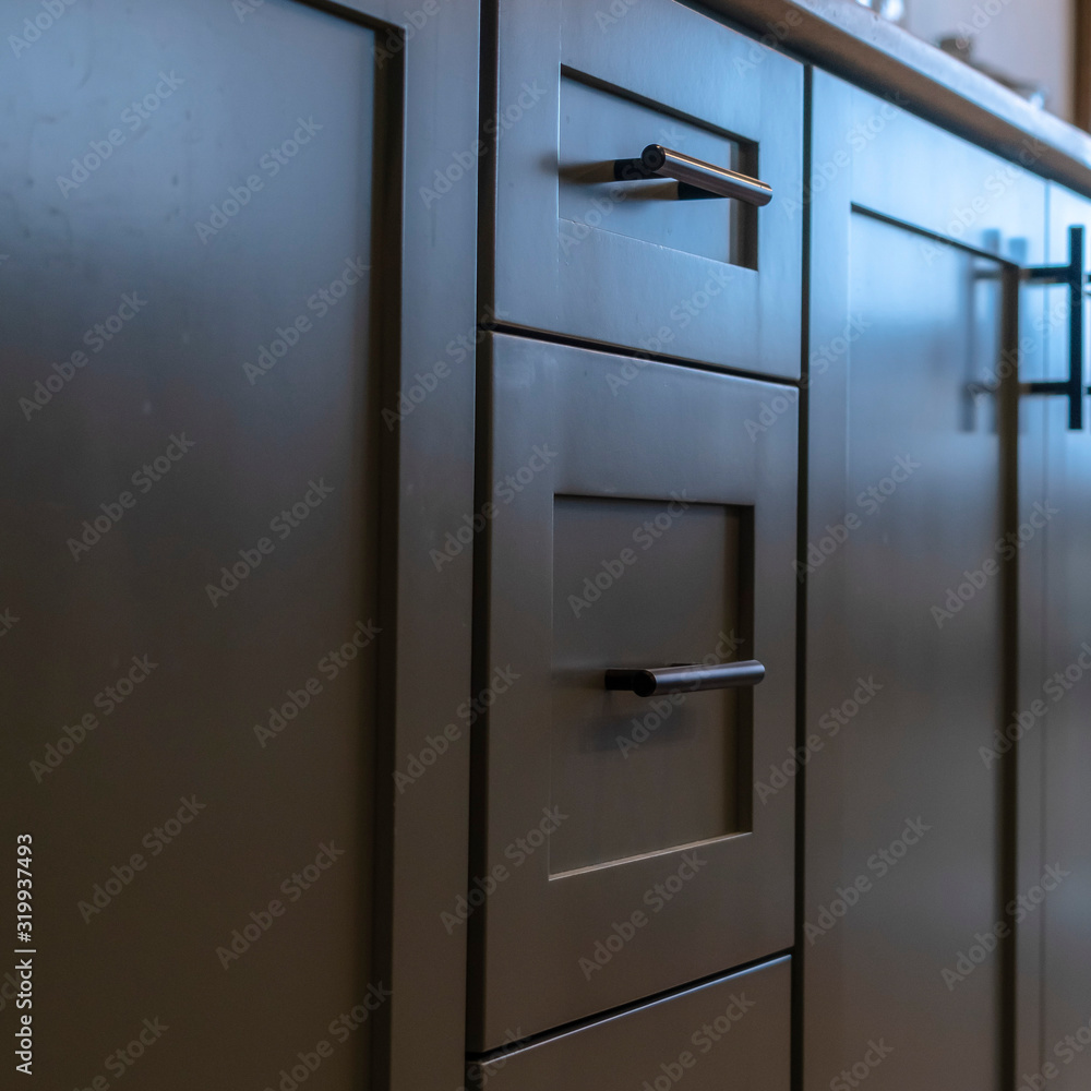 Photo Square frame Beautiful cabinetry with black handles and drawers under white countertop Photo Square frame Beautiful cabinetry with black handles and drawers under white countertop