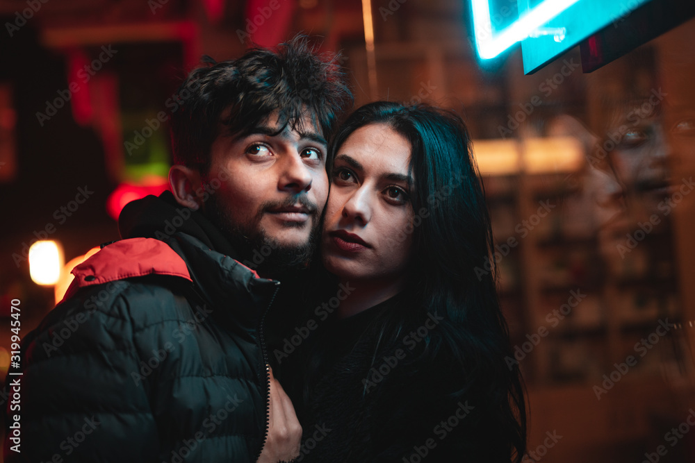Valentine's Day content, two sweet couple hugging and street themed in lighted background. Valentine's day concept pose.