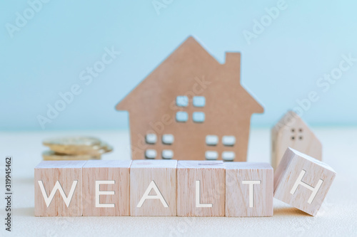 Home model and goal coins represent as money in pastel color room background. Investment wealthy freedom life.