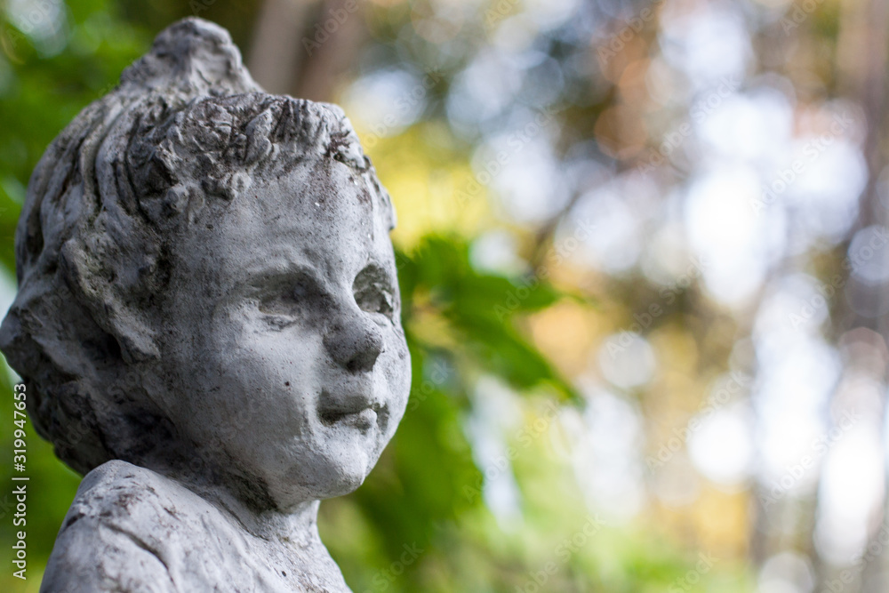 Cloes up photo of arden stone sculpture of a childern. Children statue.