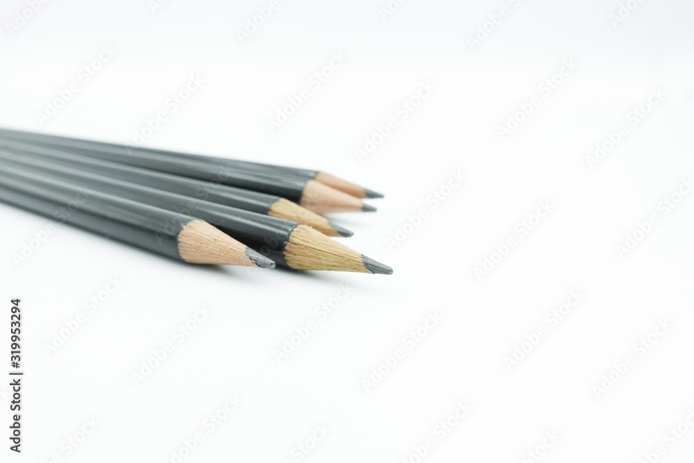 Close up of black sharpen pencils lay in a group isolated on white background with copy space. Close up of black sharpen pencils lay in a group isolated on white background with copy space.