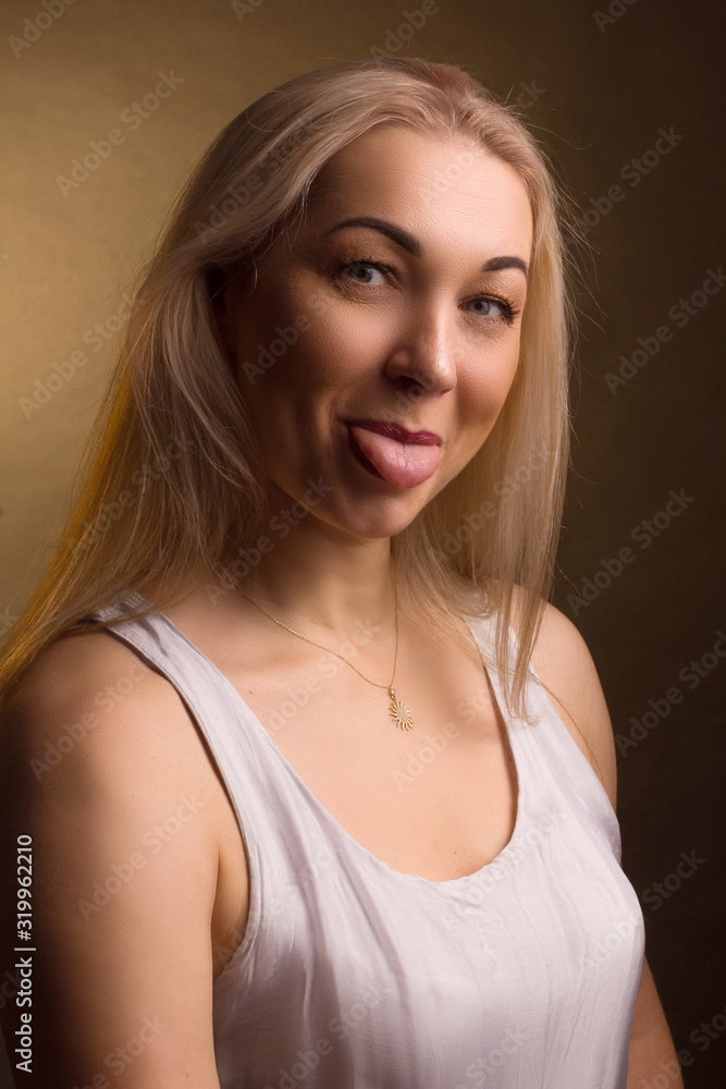 Portrait of a blonde in white dress on a light golden background Portrait of a blonde in white dress on a light golden background
