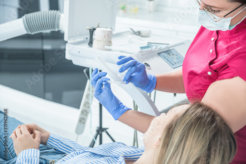 Female dentist doctor holds dental mouthguard in hands, splint therapy in dentistry to correct bite