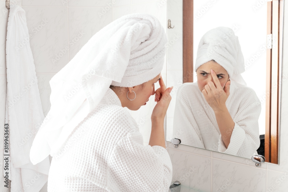 Beautiful middle-aged brunette looking at mirror and touching wrinckles on her forehead. Anti aging treatment prevention cream using Beautiful middle-aged brunette looking at mirror and touching wrinckles on her forehead. Anti aging treatment prevention cream using