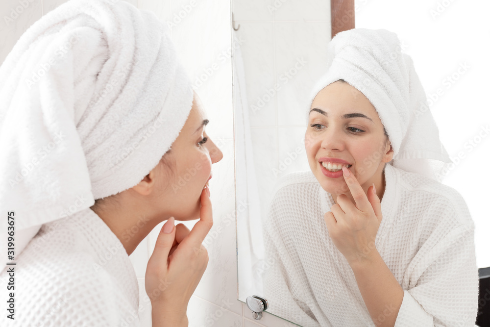 Morning hygiene routine. Pretty woman looking in the mirror on her teeth after washing and cleansing. Morning hygiene routine. Pretty woman looking in the mirror on her teeth after washing and cleansing.
