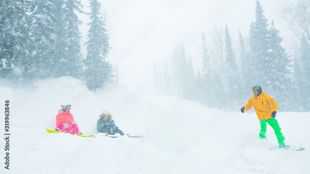 Snowboarder splashing snow on two girlfriends sitting on slope and talking. Ski slope safety rules concept.