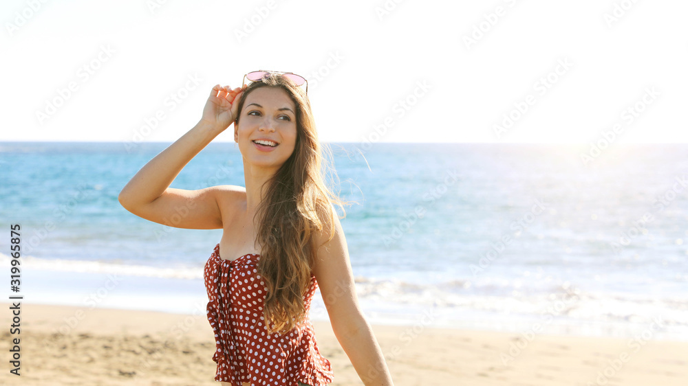 Beauty fashion tanned woman with sunglasses on her head at the sea looking to the side Beauty fashion tanned woman with sunglasses on her head at the sea looking to the side