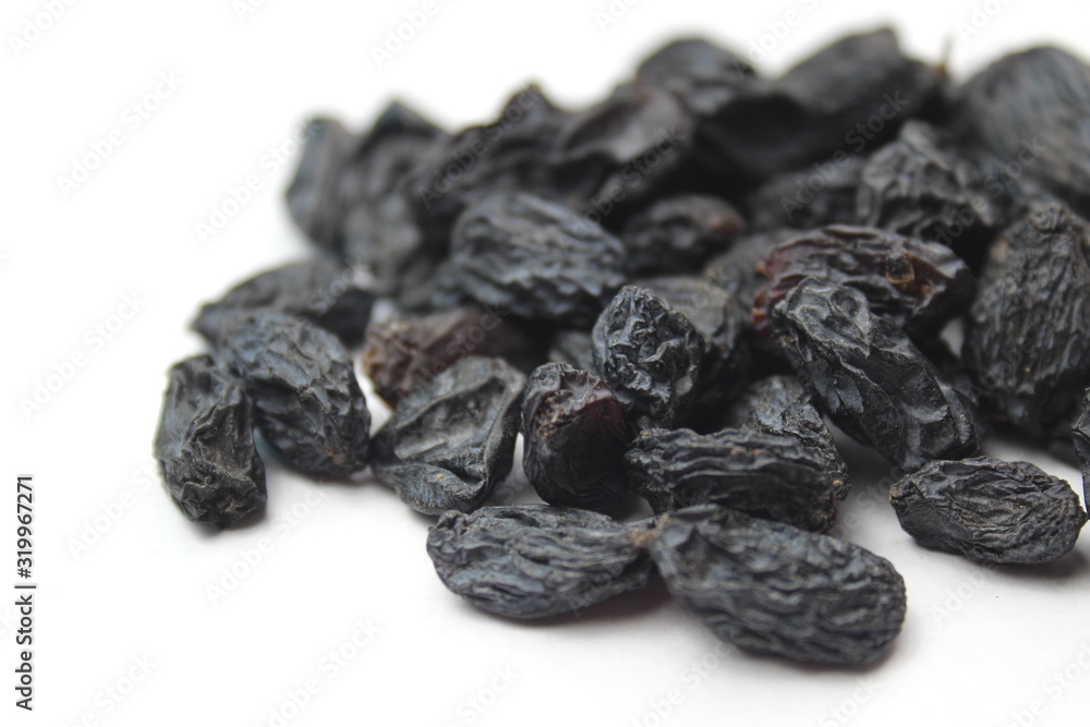 small pile of blue raisins on a white background small pile of blue raisins on a white background