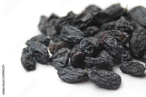 small pile of blue raisins on a white background