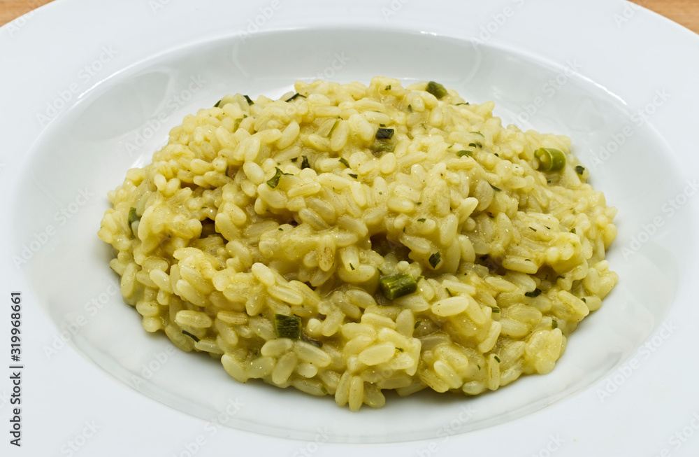 Risotto with asparagus on wooden table. Italian food close-up Risotto with asparagus on wooden table. Italian food close-up