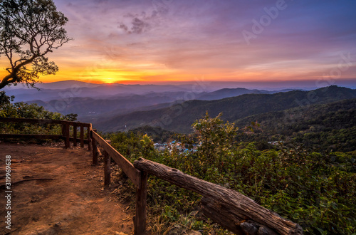 Mountain valley during sunset and village below. Beautiful landscape with forested hills