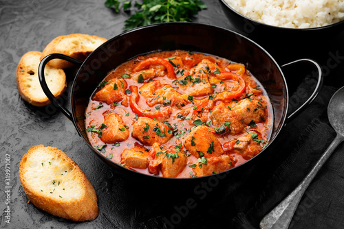 Fish Stew cooked in a delicious  rich and fragrant broth, topped with fresh parsley and served with  rice. photo