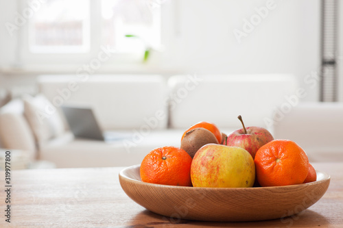 Fototapeta Naklejka Na Ścianę i Meble -  Fruit bowl in a bright living room with laptop on a couch