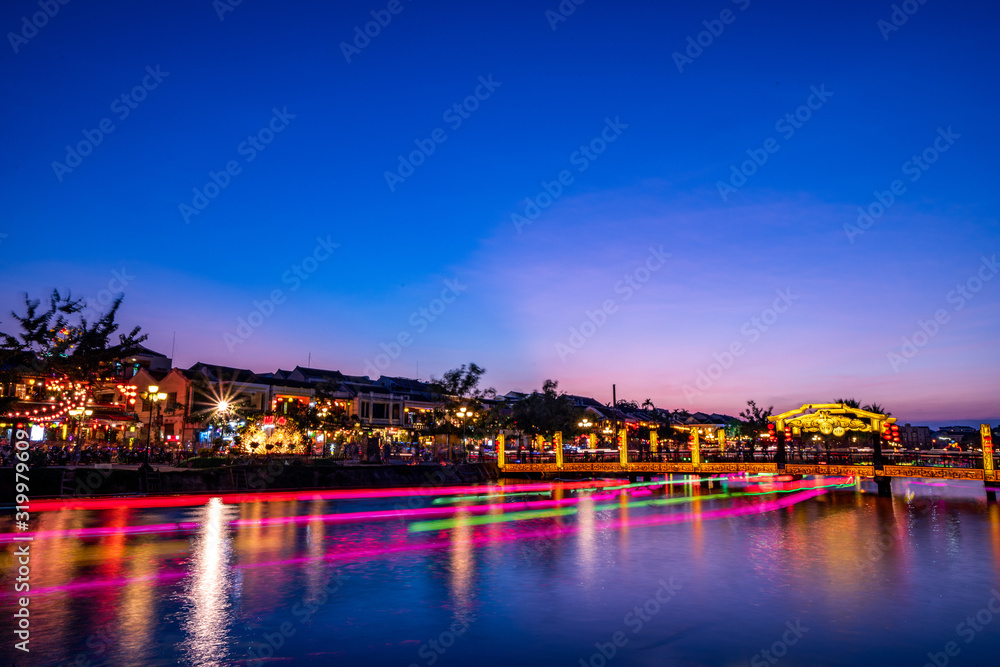 Nightscape at Hoi An old town with passenger boat light trails