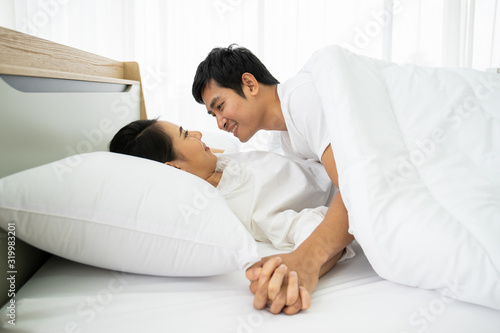 Romantic moment of young Asian couple. A couple making love together on the bed in morning. Valentine concept.
