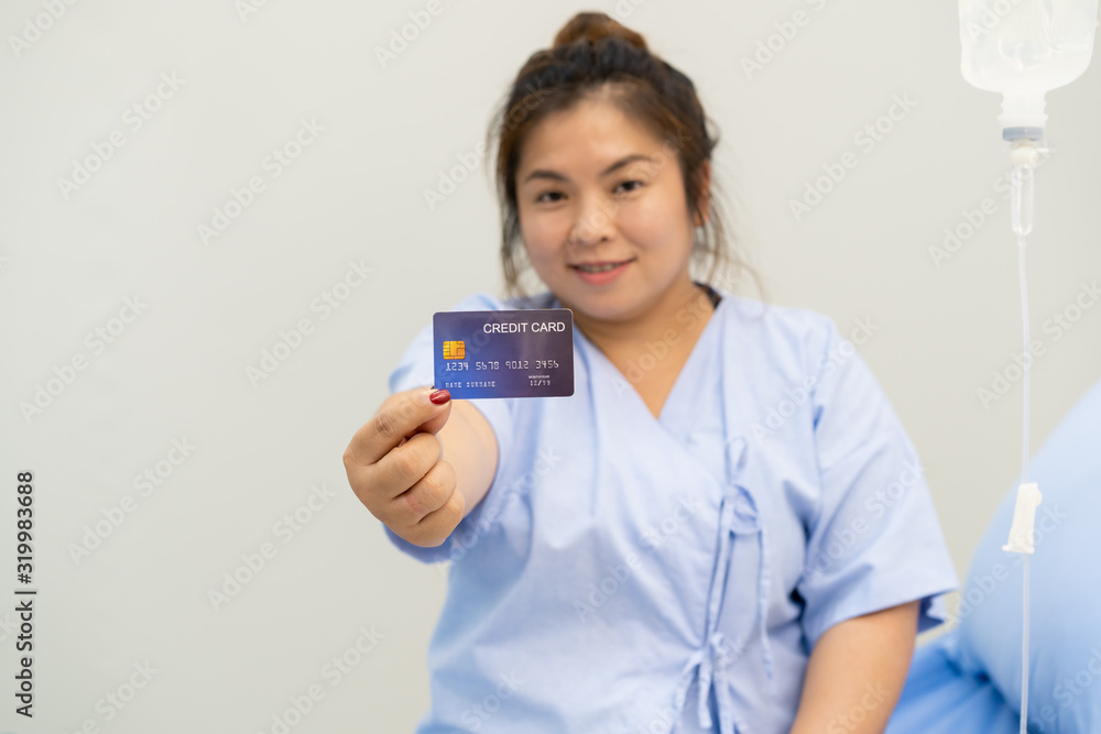 Asian fat woman stay in hospital and showing up a credit card with thumb up, financial support in medical and health care Asian fat woman stay in hospital and showing up a credit card with thumb up, financial support in medical and health care