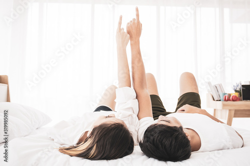 Wallpaper Mural Beautiful Asian couple laying and talking together on the bed. Couple relationship concept. Torontodigital.ca