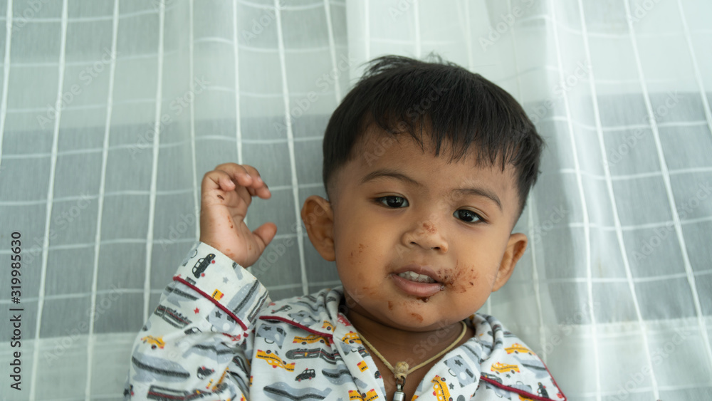 Cute little asian baby boy eatting chocolate Cute little asian baby boy eatting chocolate