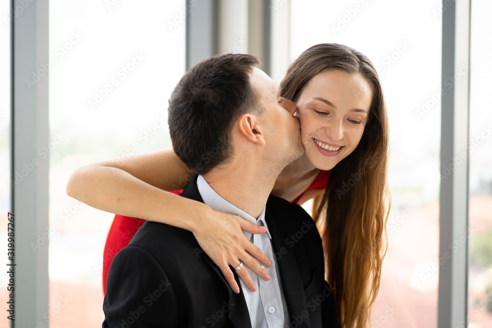 Romantic caucasian husband and wife in valentines day concept. Husband kissing on his wife tenderly. Romantic caucasian husband and wife in valentines day concept. Husband kissing on his wife tenderly.