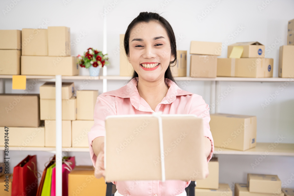 Woman and online shopping concept. Beautiful Asian happy woman holding the postal box close up.