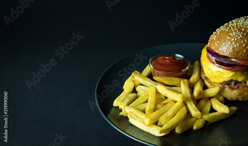 Close up view of gourmet hamburger with french fries and ketchup isolated on black 