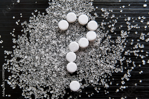 Obraz na plátně sweetener tablets lying with sugar on a dark background