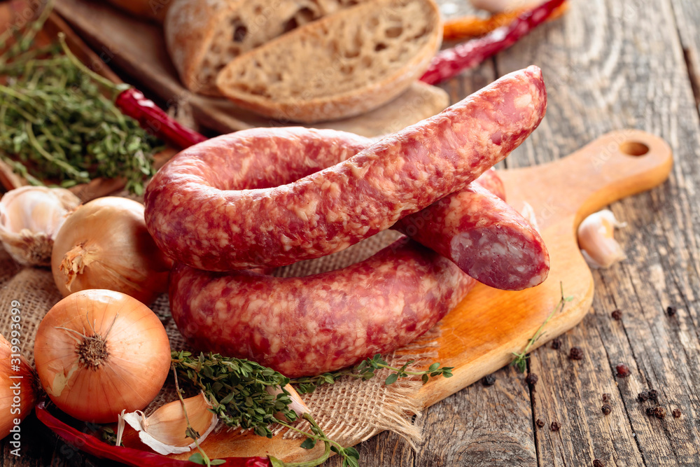 Dry-cured sausage with bread and spices on a old wooden table. Dry-cured sausage with bread and spices on a old wooden table.