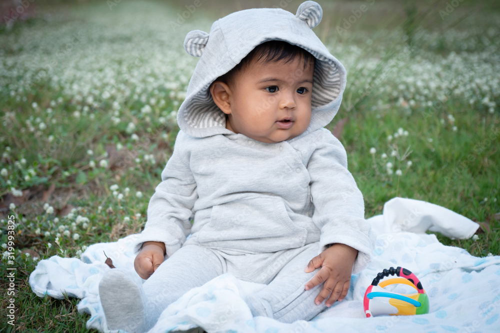 Cute little asina baby sitting at white flower garden Cute little asina baby sitting at white flower garden