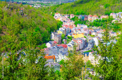 Karlovy Vary (Carlsbad) historical city centre top aerial view with colorful beautiful buildings, Slavkov Forest hills with green trees on slope, close-up, West Bohemia, Czech Republic