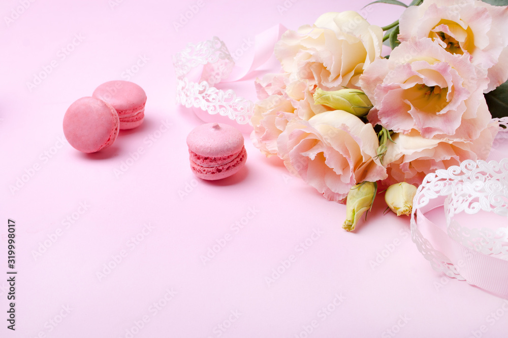 Beautiful pink eustoma flowers and macaron on a pink background Beautiful pink eustoma flowers and macaron on a pink background
