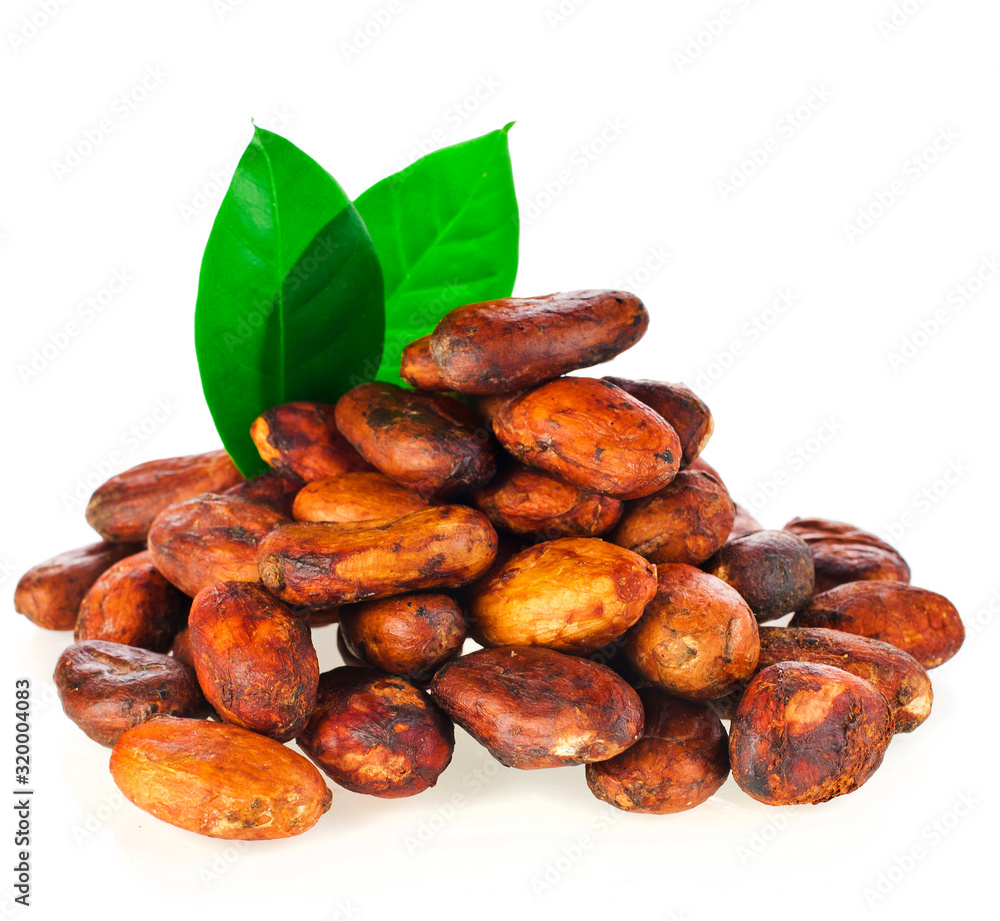 Obraz premium Heap of cacao beans with green leaves isolated on a white background.