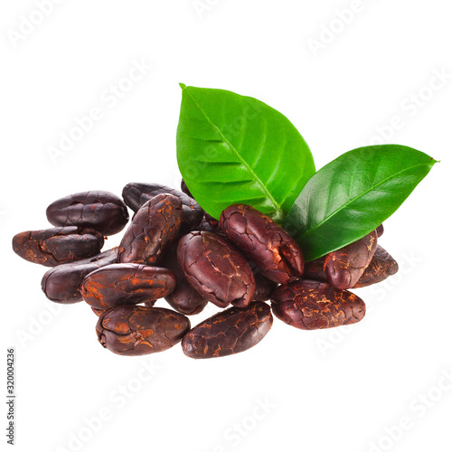 Heap of roasted cacao beans with green leaves isolated on a white background.