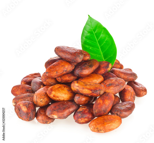 Heap of cacao beans with green leaves isolated on a white background.