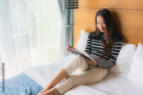 Portrait young asian woman read book in bedroom