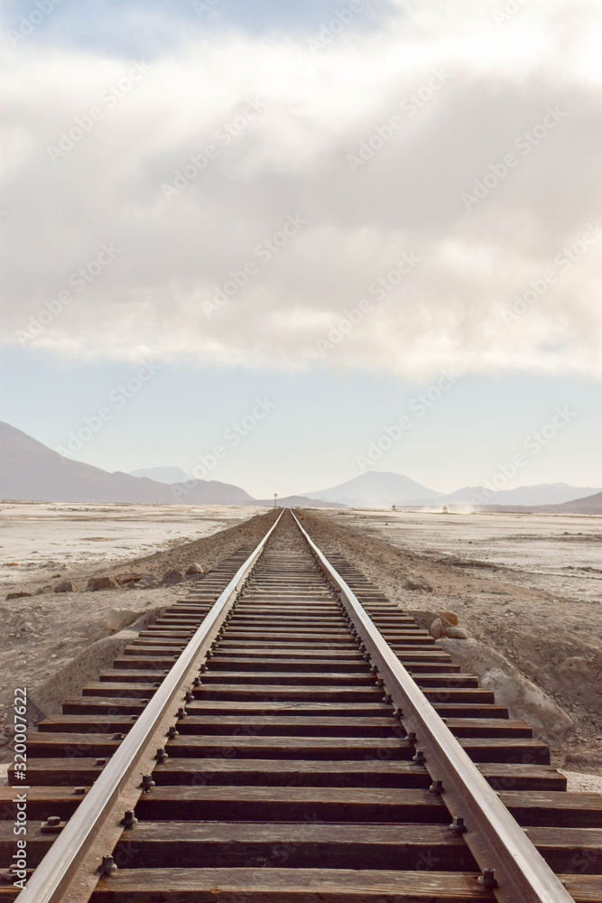 shut down rail tracks leading to the horizon in Salar de Uyuni, Bolivia