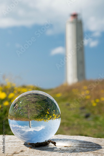 Lighthouse reflecting in a lense ball on a beautiful sunny day on Iceland