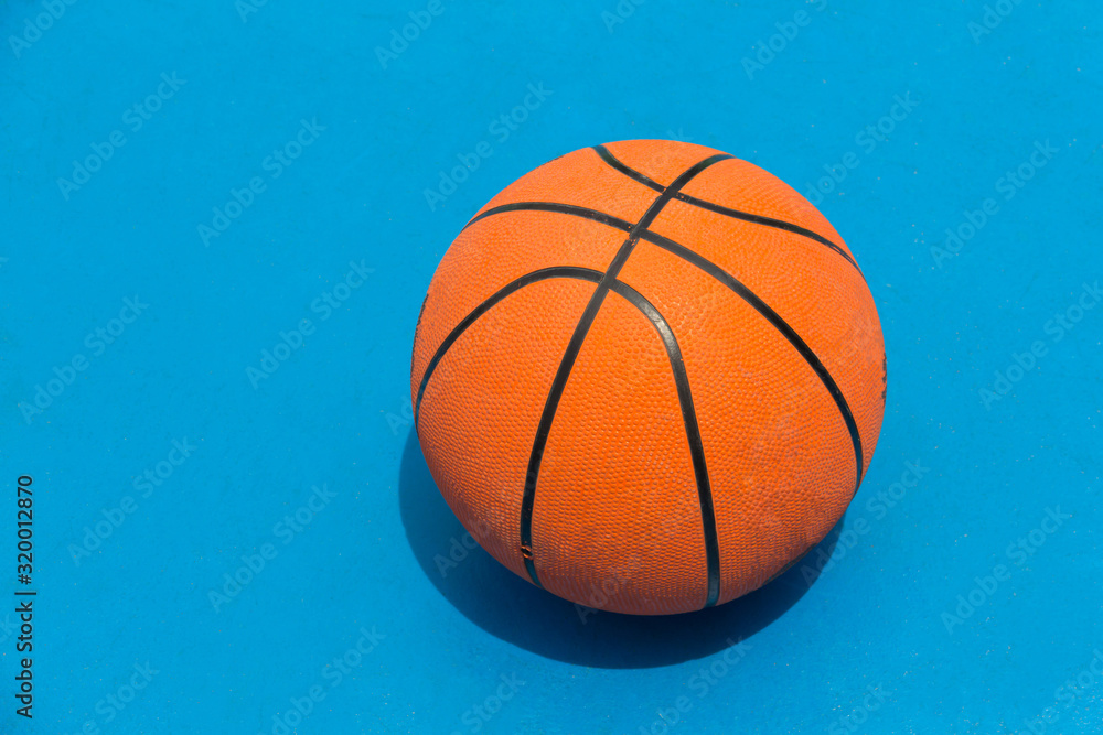 a basketball on blue court in outdoor field.