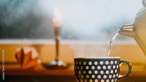 Wallpaper Mural heißes Wasser wird aus Wasserkocher in den Becher für Tee gegossen. Das Wasser Dampft. Im Hintergrund steht eine brennende Kerze. Geringe Schärfentiefe Torontodigital.ca