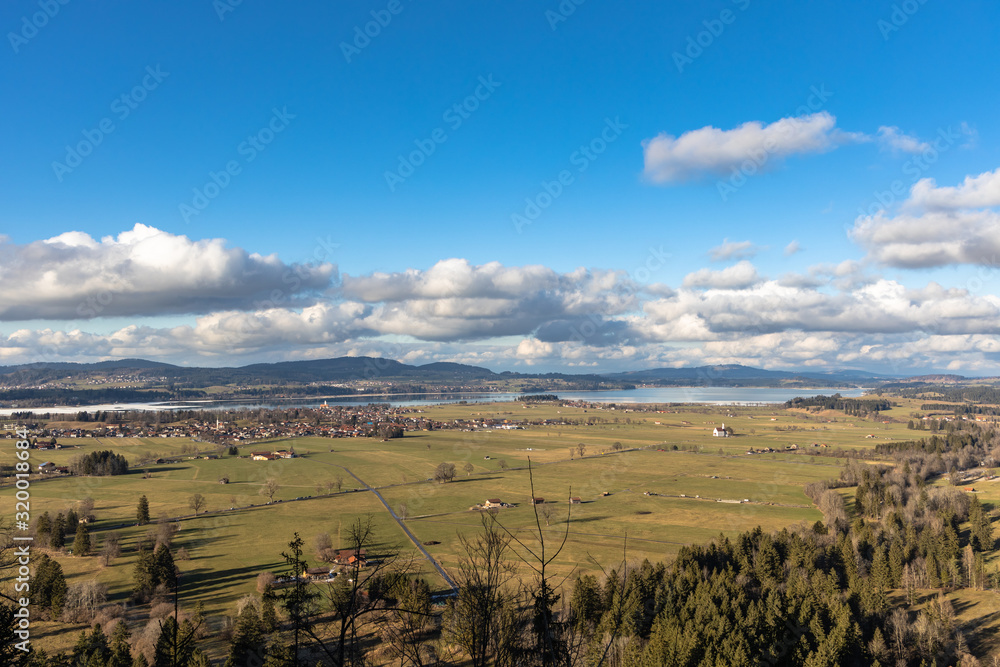 Naklejka premium Panorama view of the landscape with Forggensee lake and Bannwaldlake from Neuschwanstein Castle on a sunny winter day with blue sky cloud in background, Bavaria, Germany