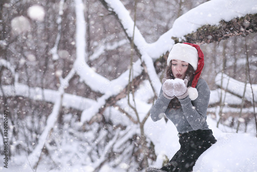 Girl in a winter park in snowfall