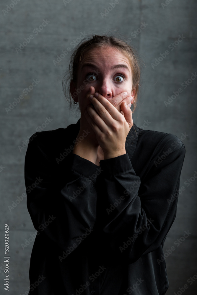 Young Caucasian Woman with Hands on Mouth and Frightened Facial Expression Young Caucasian Woman with Hands on Mouth and Frightened Facial Expression