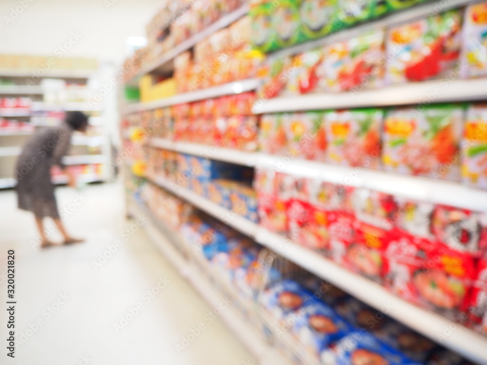 Blurred image of Dry food and instant noodles on shelves, Department store with bokeh blurred background, Abstract blurred supermarket shelf with Dry food and instant noodles as background.