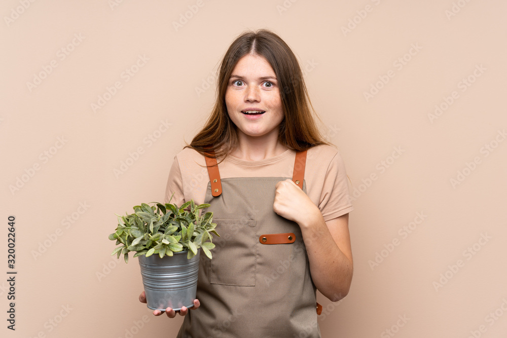 Ukrainian teenager gardener girl holding a plant celebrating a victory Ukrainian teenager gardener girl holding a plant celebrating a victory