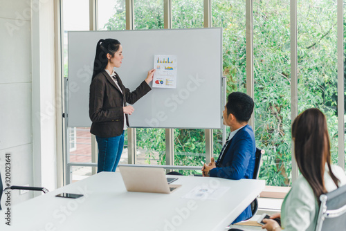 Managers and secretaries meeting and discussing business results from notebooks and paper charging statistics are in the company.