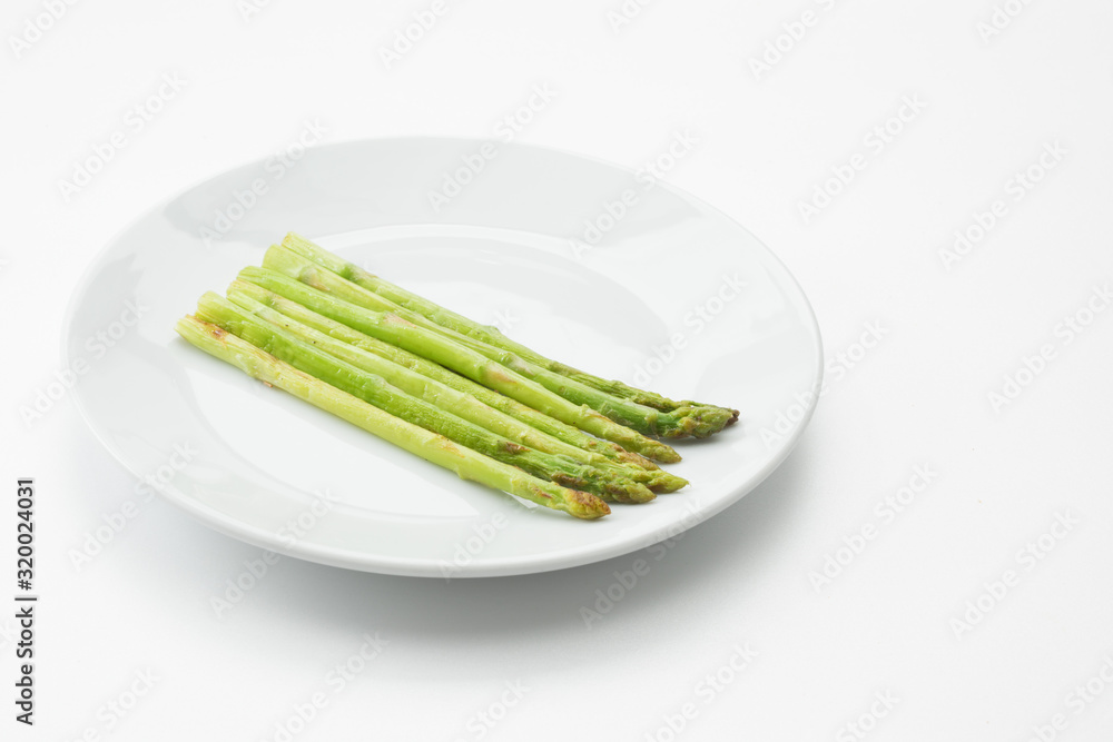 Close up view of nice yummy fried asparagus sprouts on white back Close up view of nice yummy fried asparagus sprouts on white back