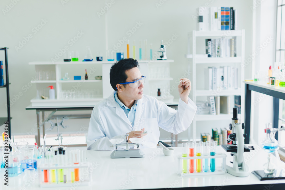 Asian scientists are preparing plant-based materials for testing and analysis in the laboratory. Scientists clear glasses and white shirts. Science and Chemistry Concept Asian scientists are preparing plant-based materials for testing and analysis in the laboratory. Scientists clear glasses and white shirts. Science and Chemistry Concept