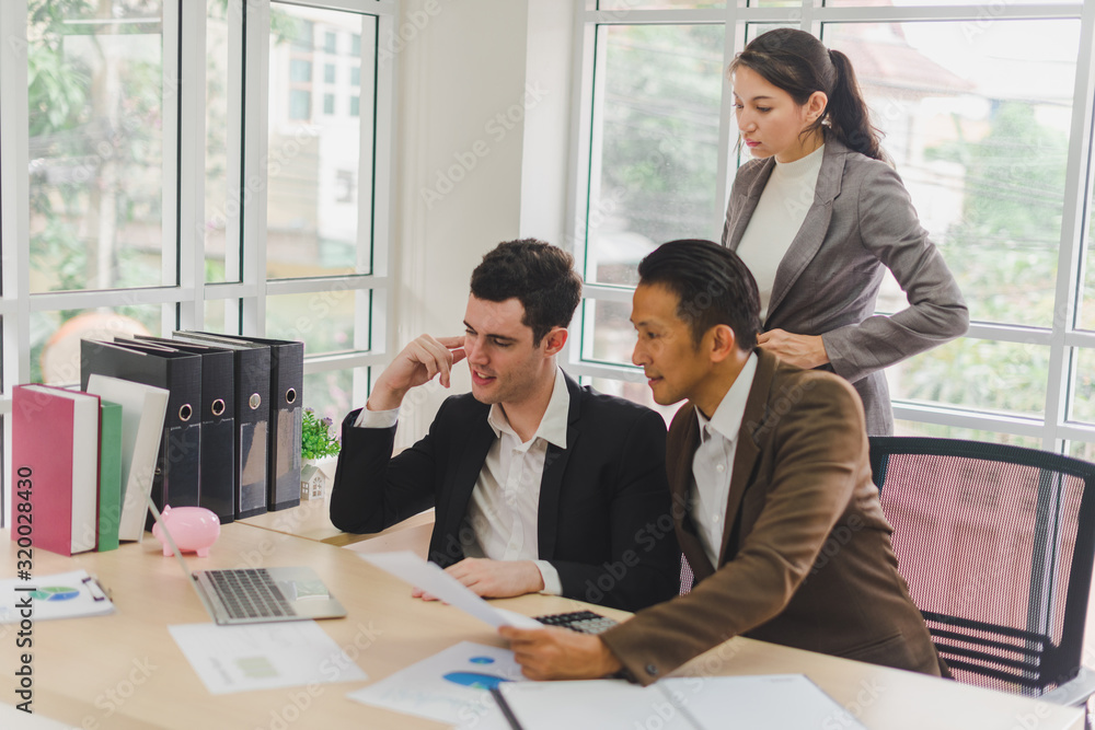 Businessmen are looking at the business plan and business results from the notebook in the office.