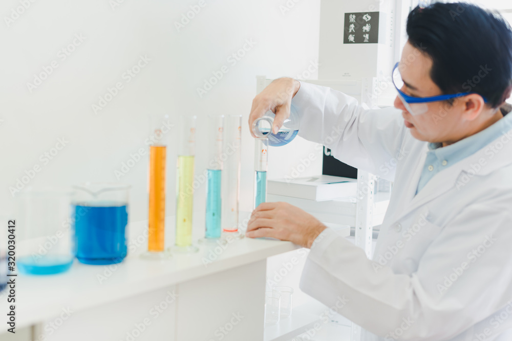 Asian scientists are preparing chemicals for testing and analysis in the laboratory. Scientists clear glasses and white shirts. Science and Chemistry Concept Asian scientists are preparing chemicals for testing and analysis in the laboratory. Scientists clear glasses and white shirts. Science and Chemistry Concept