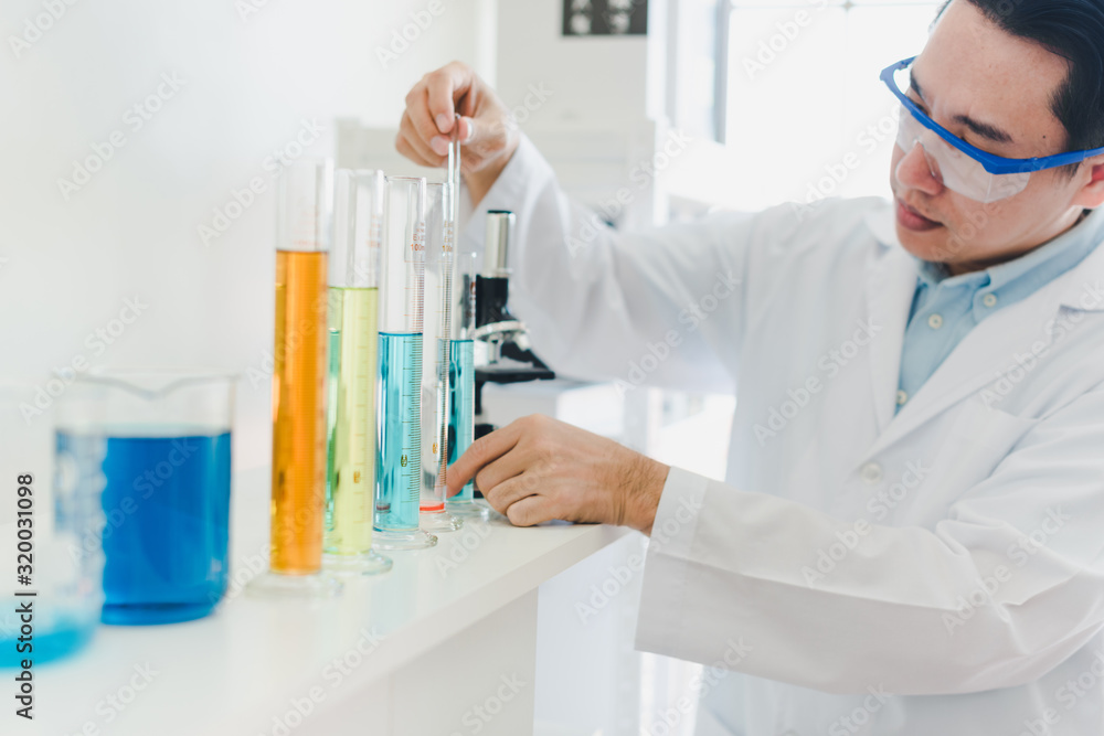 Asian scientists are preparing chemicals for testing and analysis in the laboratory. Scientists clear glasses and white shirts. Science and Chemistry Concept Asian scientists are preparing chemicals for testing and analysis in the laboratory. Scientists clear glasses and white shirts. Science and Chemistry Concept