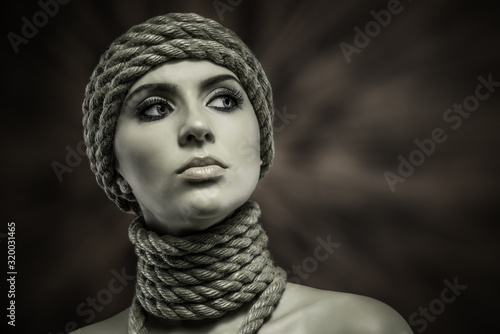 Portrait of a beautiful young woman with ropes